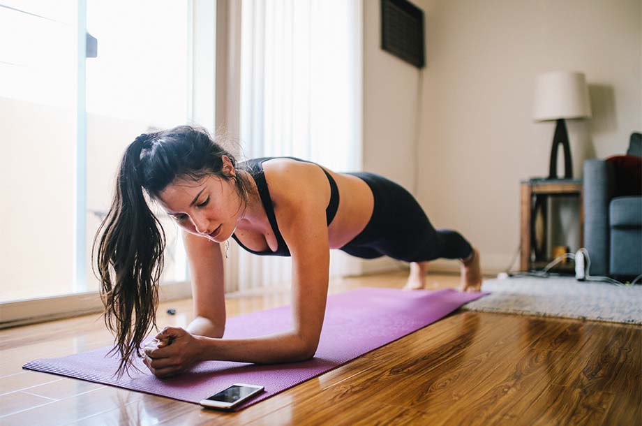 woman doing yoga while looking at phone